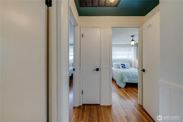 corridor featuring visible vents and wood finished floors
