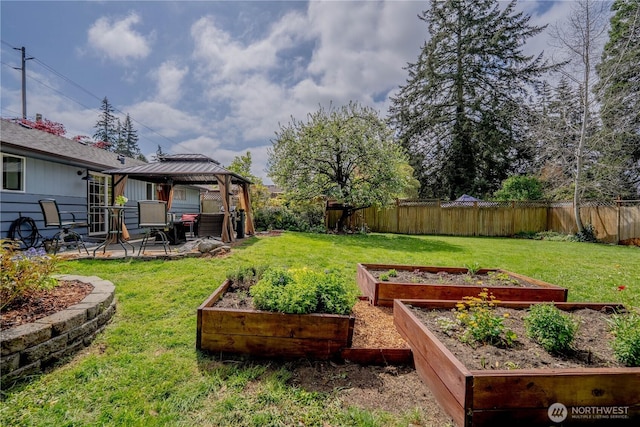 view of yard with a gazebo, a fenced backyard, a garden, and a patio area