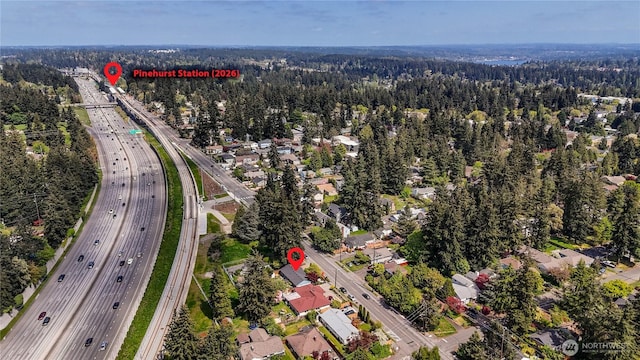 drone / aerial view featuring a residential view and a wooded view