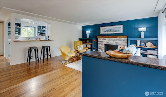 living room featuring a stone fireplace and wood finished floors