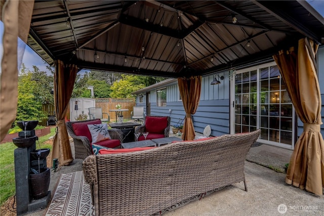 view of patio featuring fence, a storage unit, an outbuilding, and a gazebo