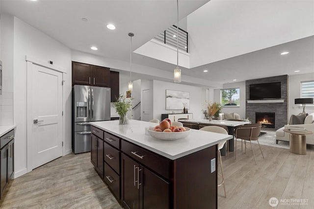 7872 198th Avenue Pl E, Bonney Lake, WA 98391 - kitchen featuring stainless steel fridge with ice dispenser, a center island, light wood finished floors, light countertops, and recessed lighting