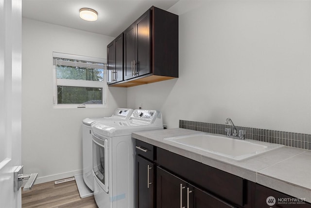 7872 198th Avenue Pl E, Bonney Lake, WA 98391 - laundry room featuring cabinet space, washer and clothes dryer, light wood-type flooring, and baseboards