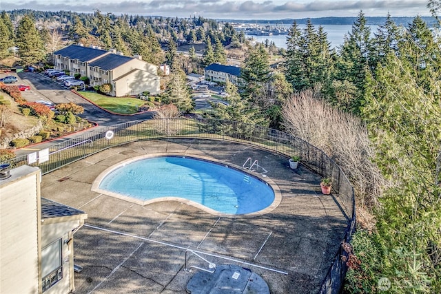 community pool featuring fence and a patio area