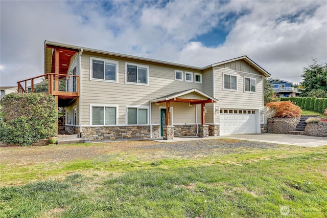 5195 NE Cedar Ln, Hansville, WA 98340 - view of front of property featuring a front yard, an attached garage, stone siding, board and batten siding, and concrete driveway