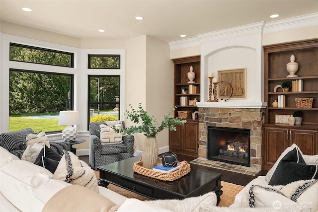 living room featuring ornamental molding, recessed lighting, wood finished floors, and a fireplace
