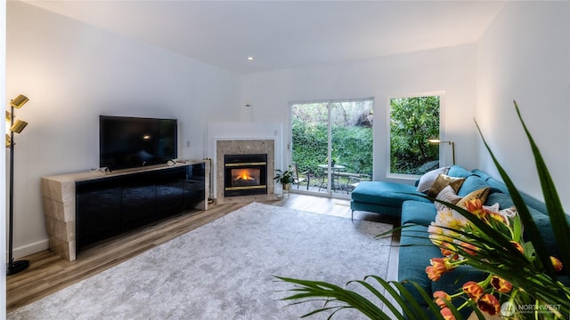 living area with a fireplace with flush hearth, wood finished floors, baseboards, and recessed lighting