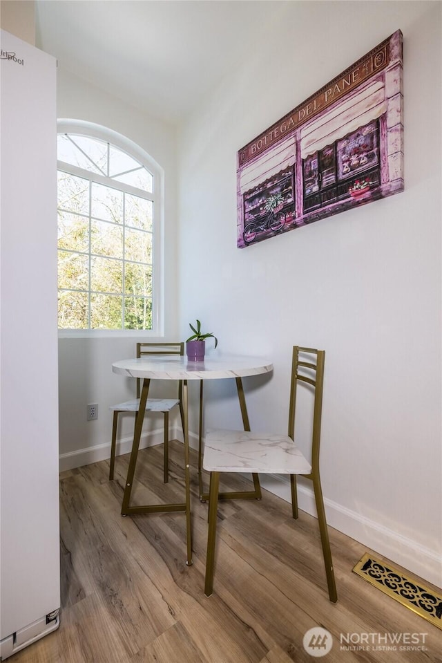 dining space with wood finished floors and baseboards