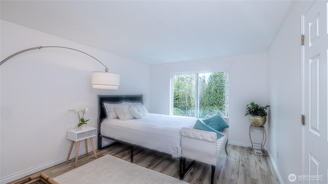 bedroom featuring wood finished floors and baseboards