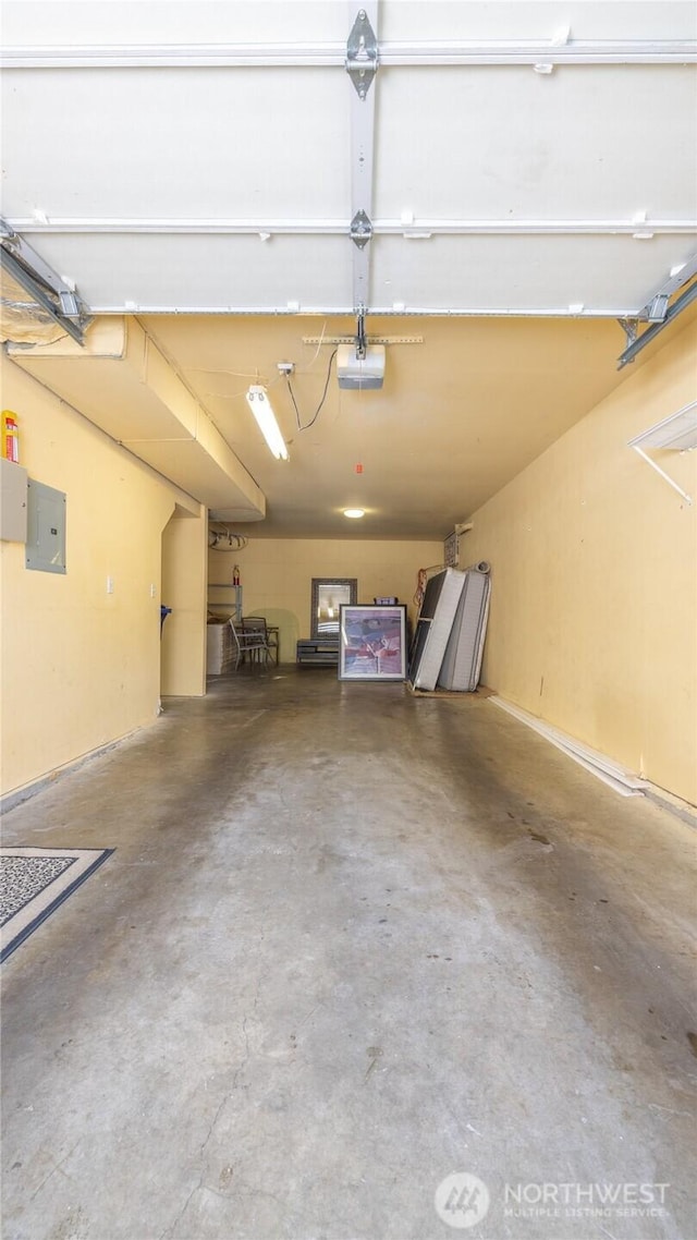 garage with a garage door opener and electric panel