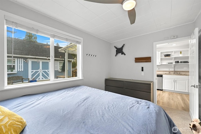 bedroom with light colored carpet, a sink, and ensuite bath