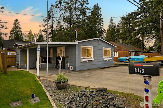 view of front facade with a yard, a patio area, and fence