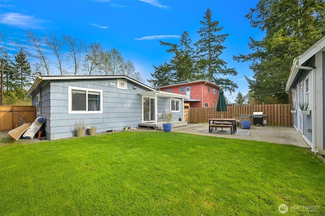 back of house featuring a yard, a fenced backyard, and a patio area