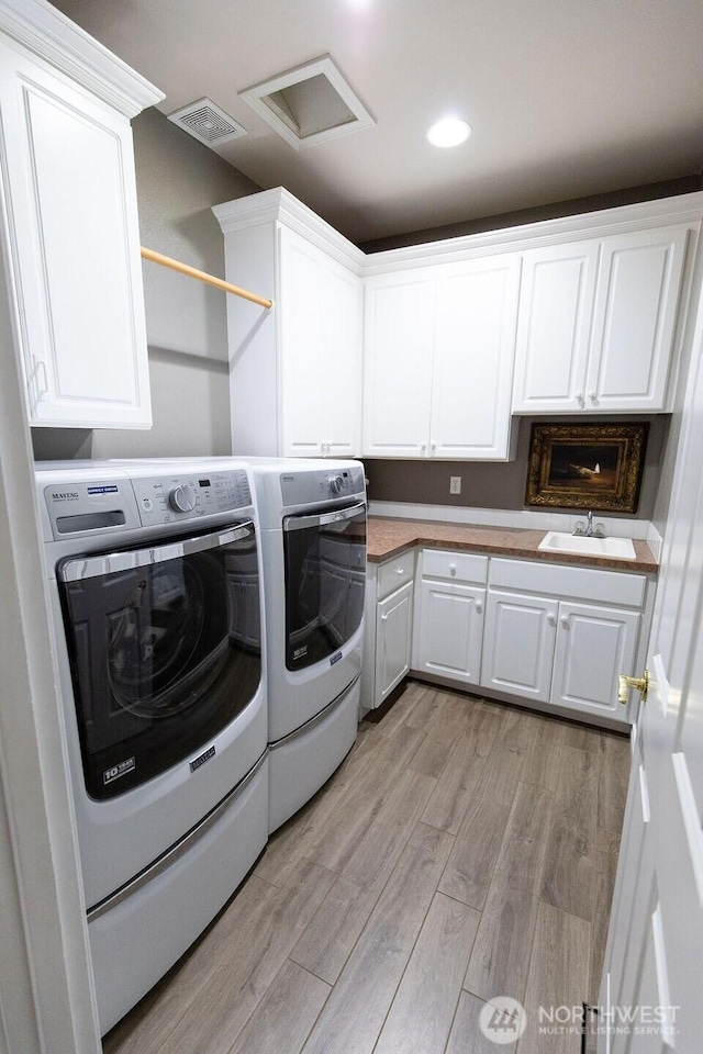 2021 Broadhurst Pl, Wenatchee, WA 98801 - clothes washing area featuring washing machine and clothes dryer, cabinet space, light wood finished floors, and attic access