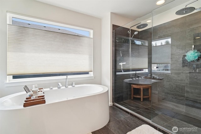 bathroom with a stall shower and a freestanding tub