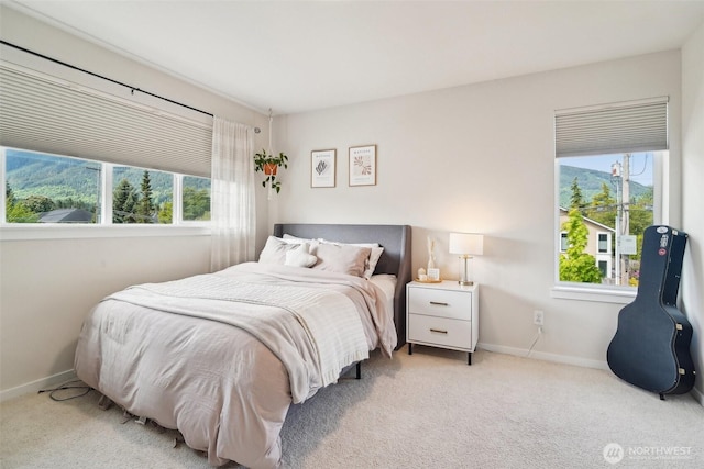 bedroom with light colored carpet and baseboards