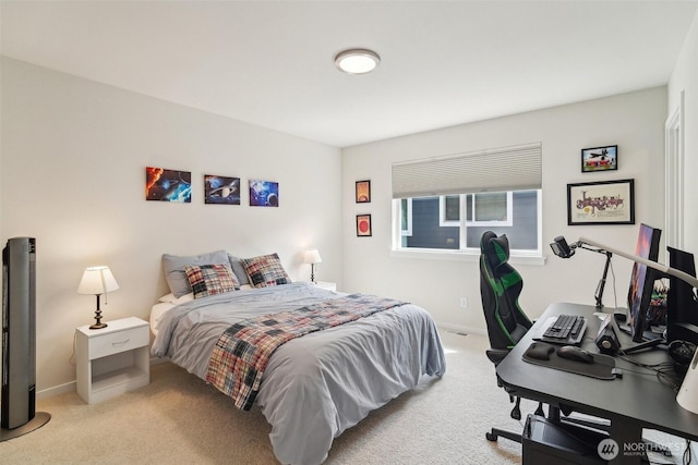 carpeted bedroom featuring baseboards and a desk