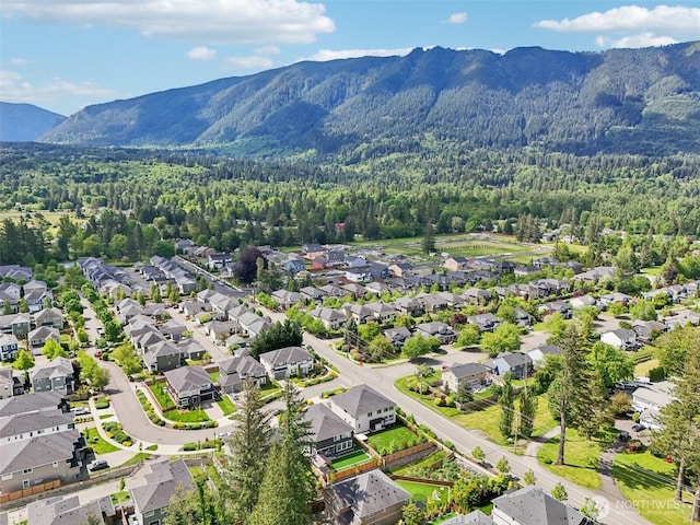 aerial perspective of suburban area featuring a heavily wooded area and mountains