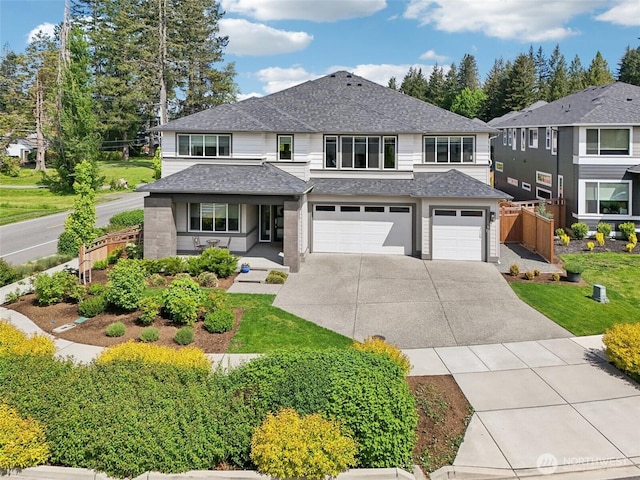 view of front of home with driveway, a garage, and roof with shingles