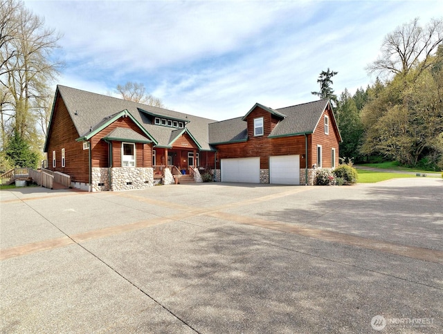 view of front of house featuring roof with shingles, stone siding, a garage, and concrete driveway