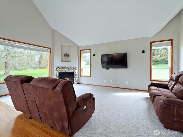 carpeted living room featuring baseboards, a stone fireplace, and lofted ceiling