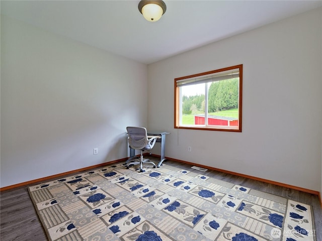 unfurnished office with light wood finished floors, baseboards, and visible vents