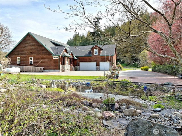 exterior space featuring fence, a garage, and driveway