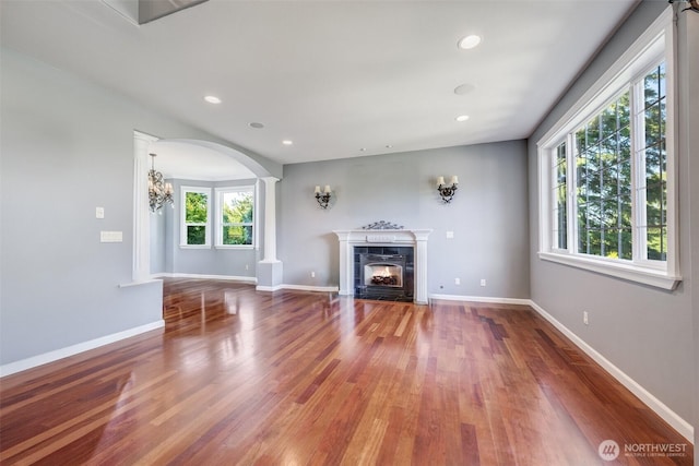 36984 Aspen Way NE, Hansville, WA 98340 - unfurnished living room with a fireplace, wood finished floors, arched walkways, baseboards, and recessed lighting