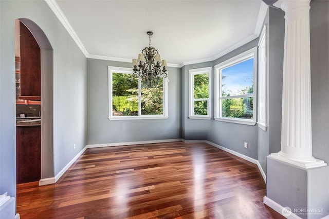 36984 Aspen Way NE, Hansville, WA 98340 - unfurnished dining area featuring decorative columns, crown molding, wood finished floors, baseboards, and a chandelier