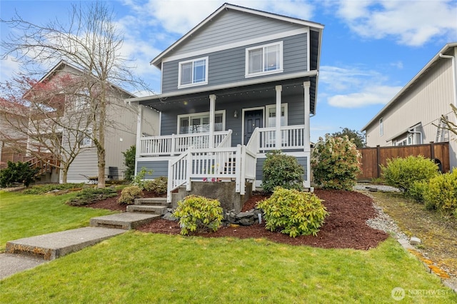 view of front of property featuring a porch, a front yard, fence, and stairway