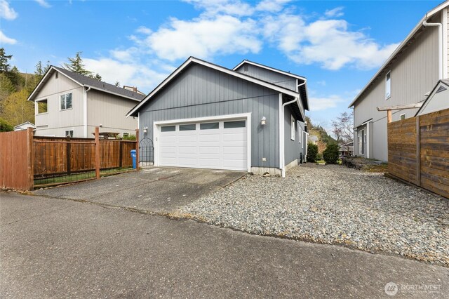 exterior space featuring driveway, a garage, and fence