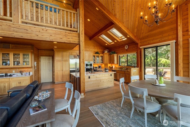 121 Marine Dr, Blakely Island, WA 98222 - dining space with a chandelier, high vaulted ceiling, wooden walls, and dark wood finished floors