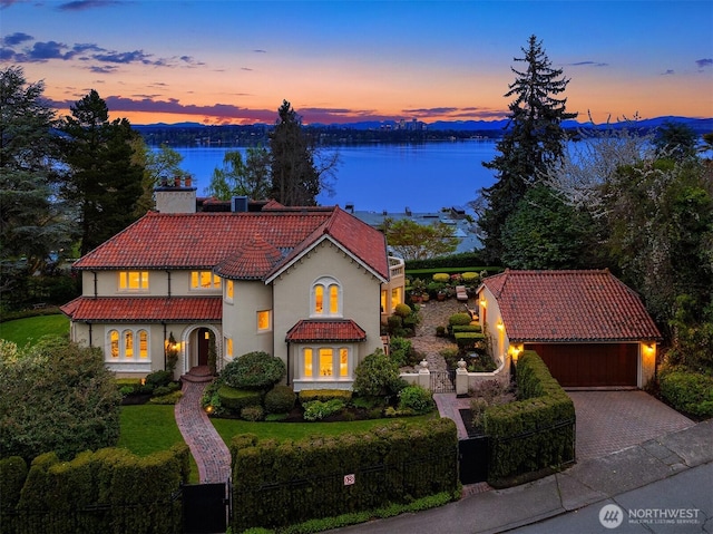 180 Lake Washington Blvd E, Seattle, WA 98112 - mediterranean / spanish-style house featuring a fenced front yard, stucco siding, a water view, a tile roof, and driveway