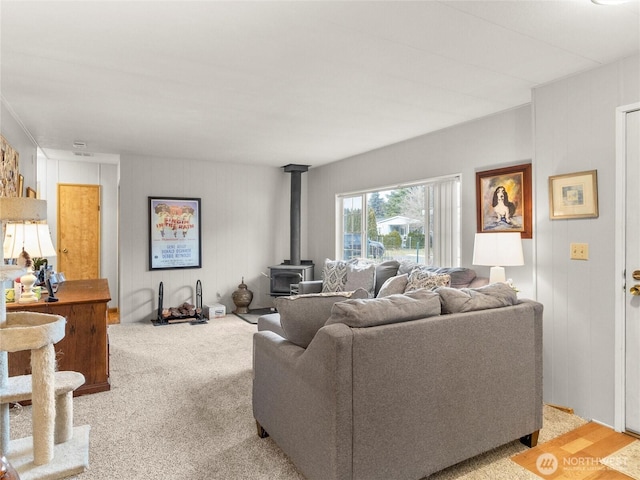 living room with a wood stove and light carpet