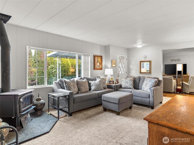 living area with carpet floors and a wood stove