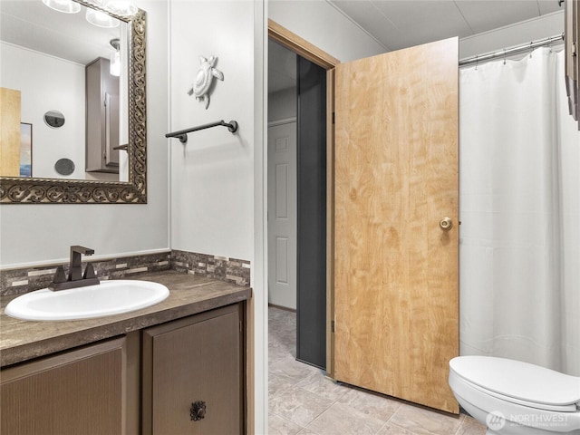 full bath featuring toilet, vanity, and a shower with curtain