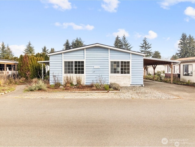 view of front of home with concrete driveway and an attached carport