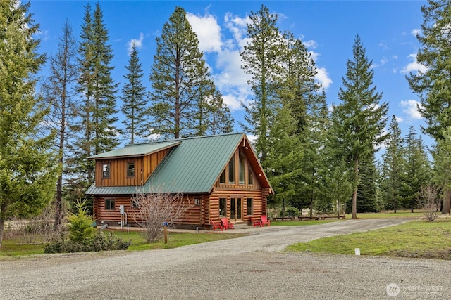 exterior space featuring a yard, log siding, and metal roof