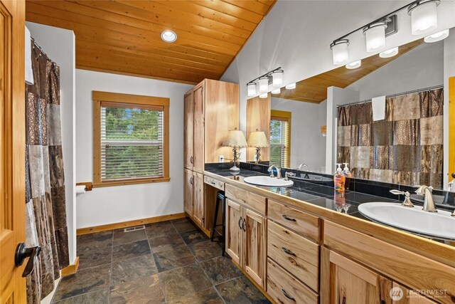 bathroom with a sink, baseboards, a wealth of natural light, and wood ceiling