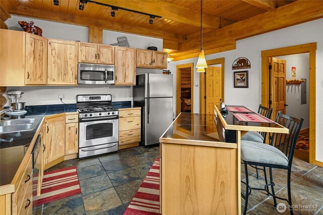 kitchen with wooden ceiling, a sink, beam ceiling, stone tile floors, and stainless steel appliances