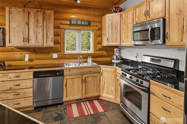 kitchen featuring log walls, visible vents, appliances with stainless steel finishes, a sink, and light brown cabinetry
