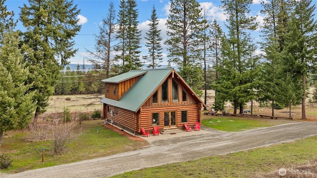 log cabin with driveway, a front yard, log exterior, a standing seam roof, and metal roof