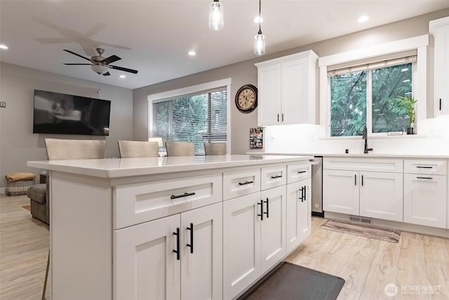 6321 Pony Pl, Maple Falls, WA 98266 - kitchen with light wood-style flooring, a ceiling fan, a kitchen island, a wealth of natural light, and a sink