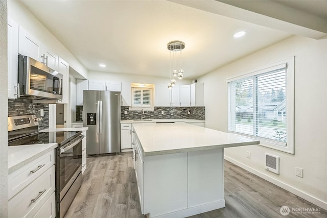 1016 Dearborn Ave, Shelton, WA 98584 - kitchen with decorative backsplash, appliances with stainless steel finishes, light wood finished floors, and light countertops