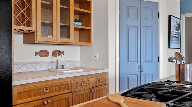 4504 Queen Ann Way, Anacortes, WA 98221 - kitchen with a sink, light countertops, glass insert cabinets, and brown cabinetry