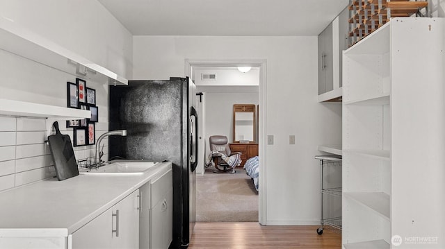 4504 Queen Ann Way, Anacortes, WA 98221 - kitchen with open shelves, light wood finished floors, freestanding refrigerator, light countertops, and a sink