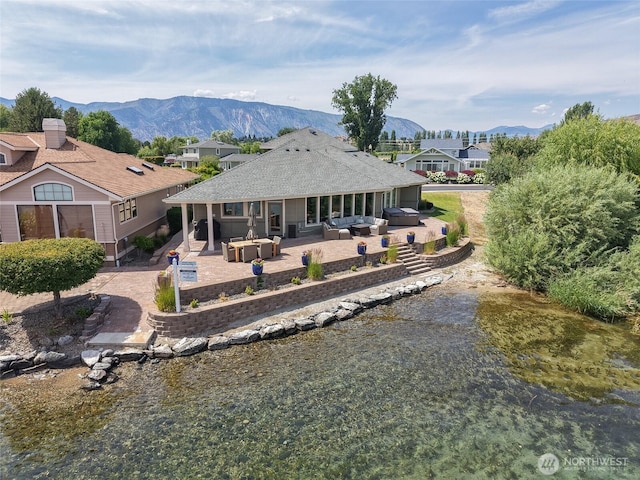 215 Wall St, Manson, WA 98831 - rear view of property featuring outdoor lounge area, a patio area, a mountain view, and a hot tub