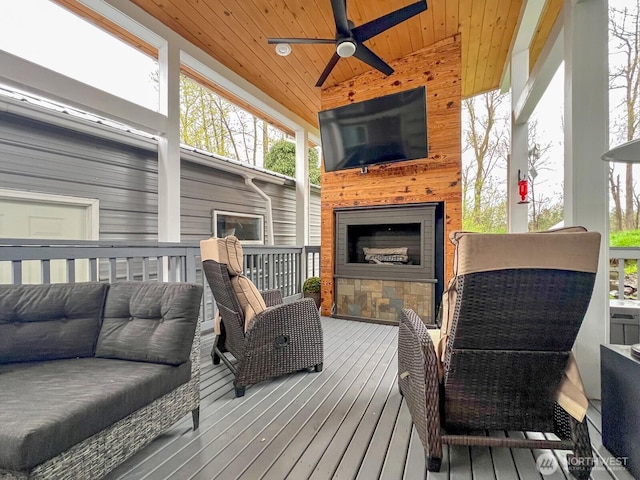 wooden terrace featuring an outdoor living space with a fireplace and ceiling fan