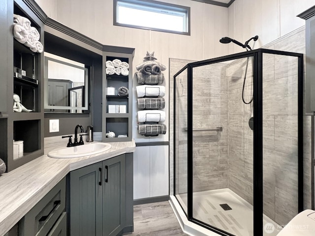 full bathroom featuring vanity, a stall shower, and wood finished floors