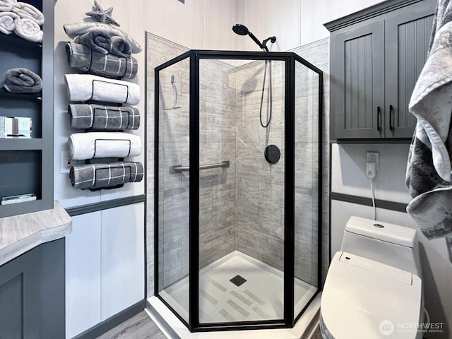 bathroom with a shower stall and toilet
